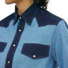 Blue denim shirt with navy accents on a white background