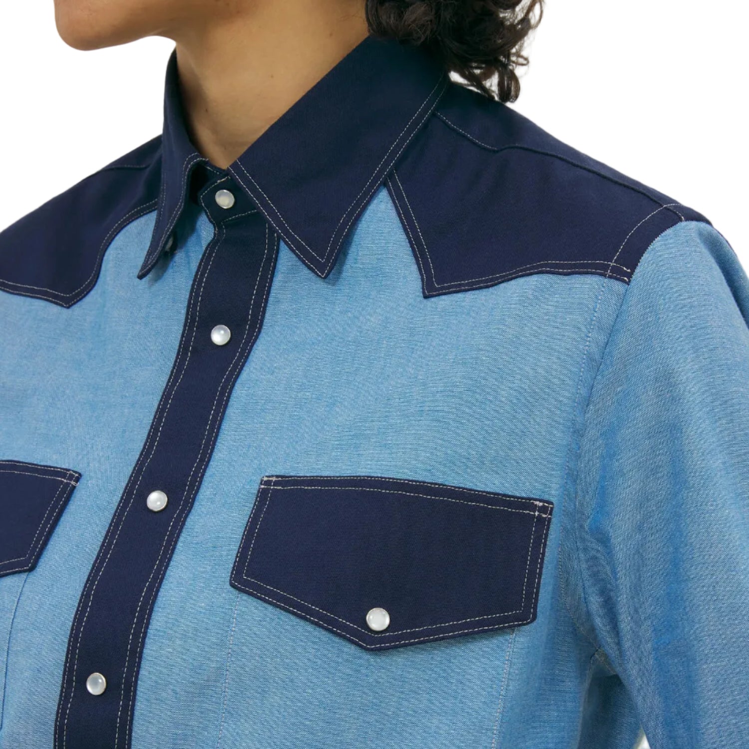 Blue denim shirt with navy accents on a white background