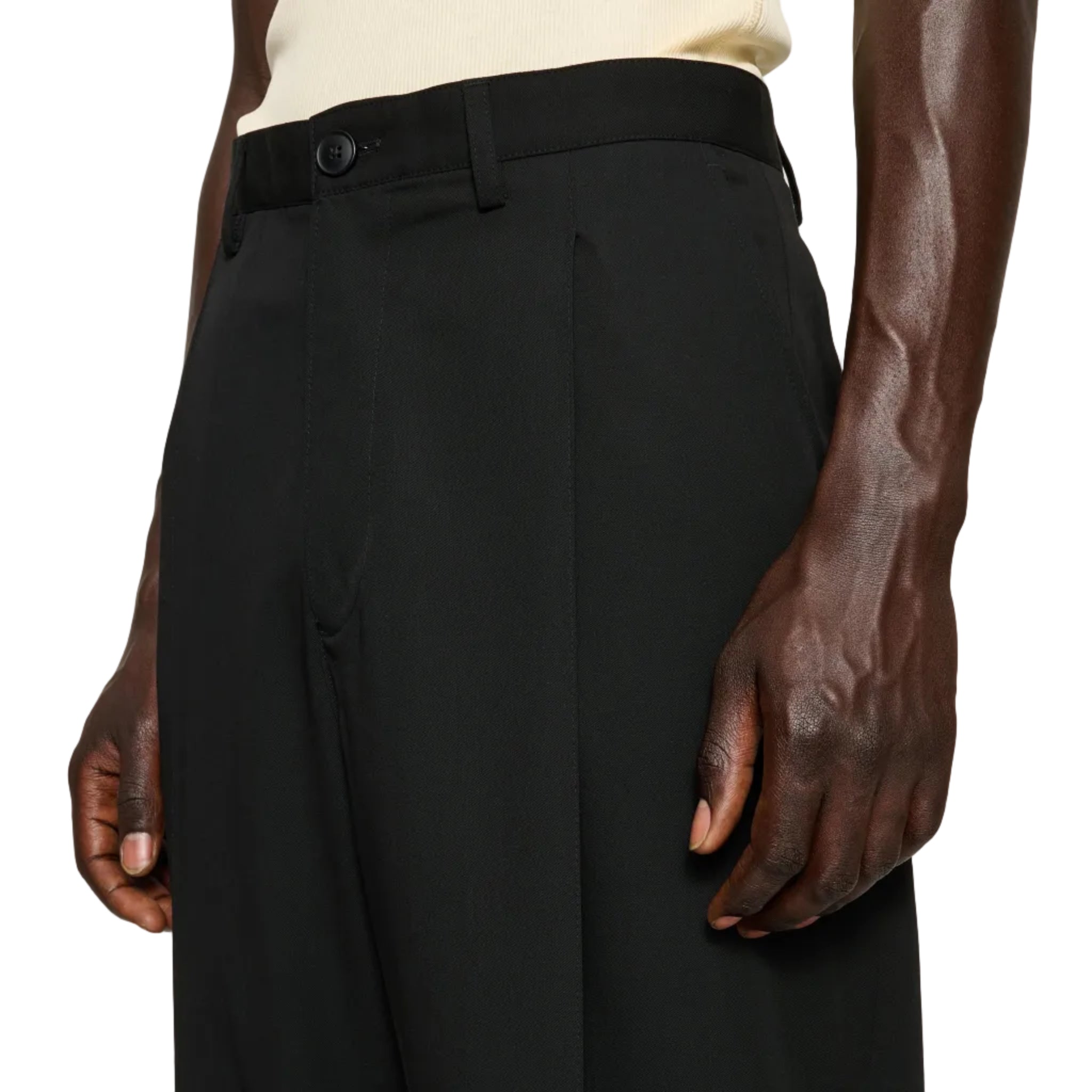 Person wearing black pants on a plain background