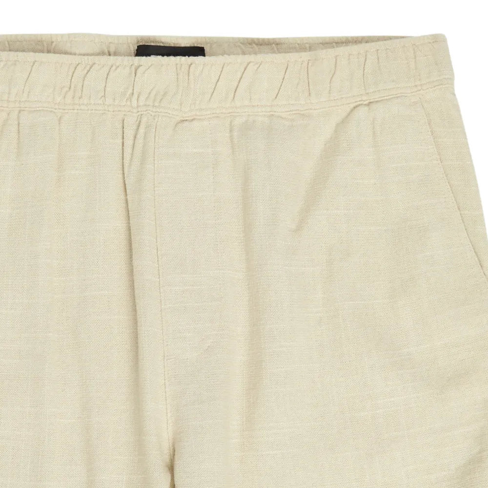 Beige pants with a brand label on a white background