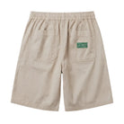 Beige shorts with a green label on a white background, back view