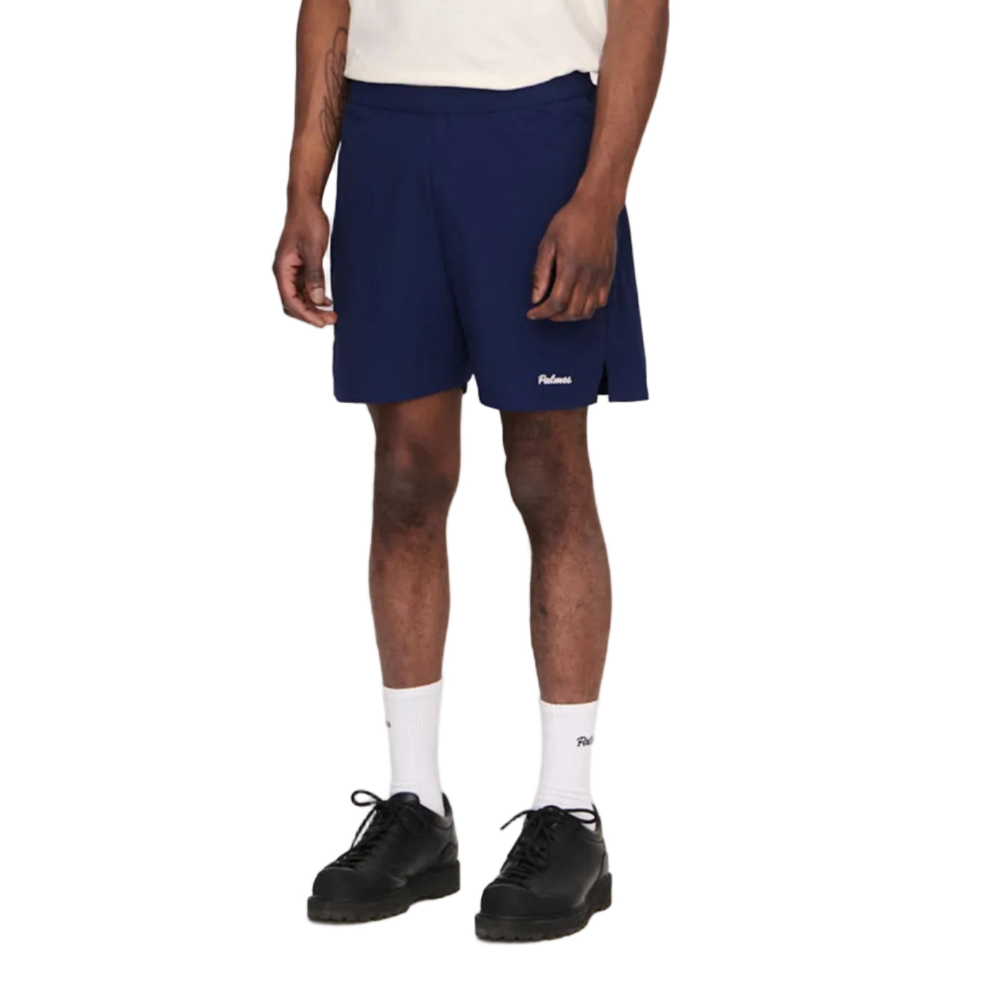 Man wearing a white t-shirt and navy shorts on a plain background