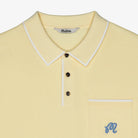 Yellow polo shirt with white trim and a small logo on a light gray background