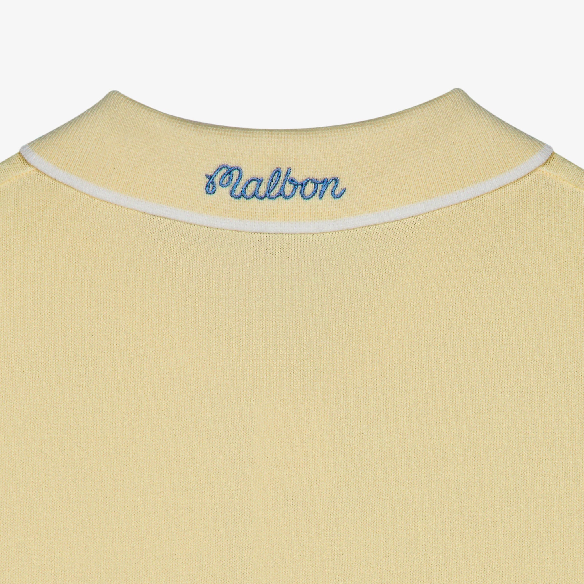 Yellow shirt with 'Malbon' branding on a white background
