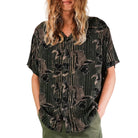 Person wearing a patterned shirt and green pants on a white background