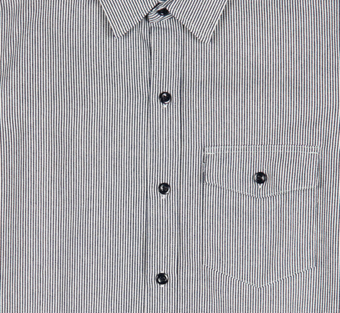 Close-up of an indigo and white striped shirt with buttons and a pocket.