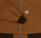 Close-up of a brown jacket with a visible brand label on the front pocket.