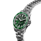 Shinola watch with green face and silver metal band on white background