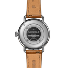 Silver back of watch with a tan band on a white background