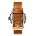 Brown leather watch strap with gold buckle on a white background
