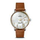 Gold watch with white face and tan band on a white background