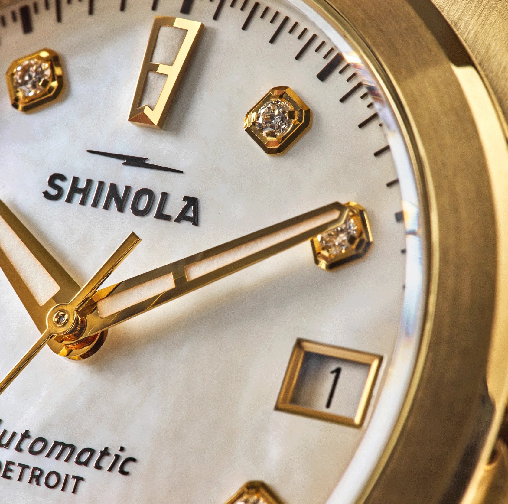 Shinola watch face with gold and diamond accents and 'Shinola' branding.