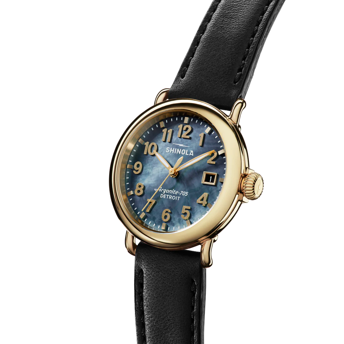 Shinola watch with black leather strap and gold case on white background