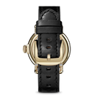 Watch with black leather strap and gold case on a white background