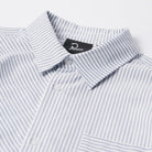 Close-up of a striped shirt with a brand label on a light gray background