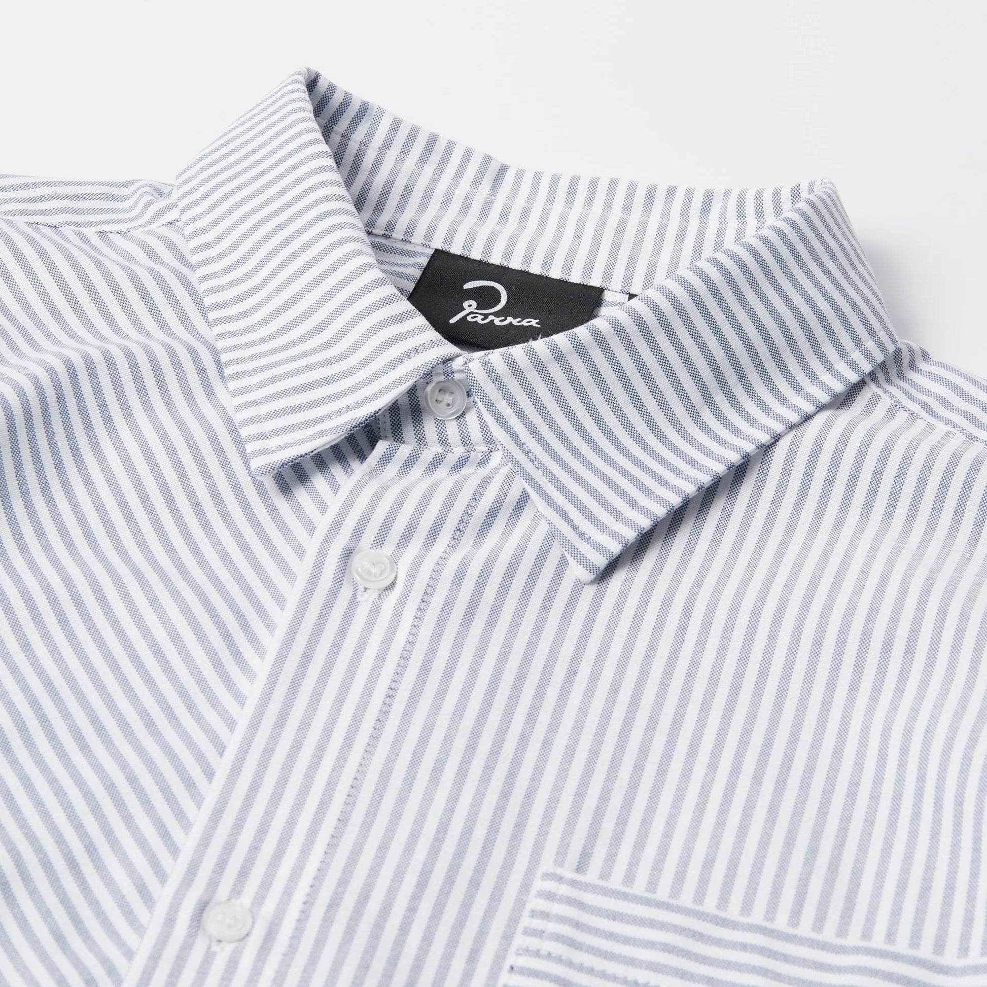 Close-up of a striped shirt with a brand label on a light gray background