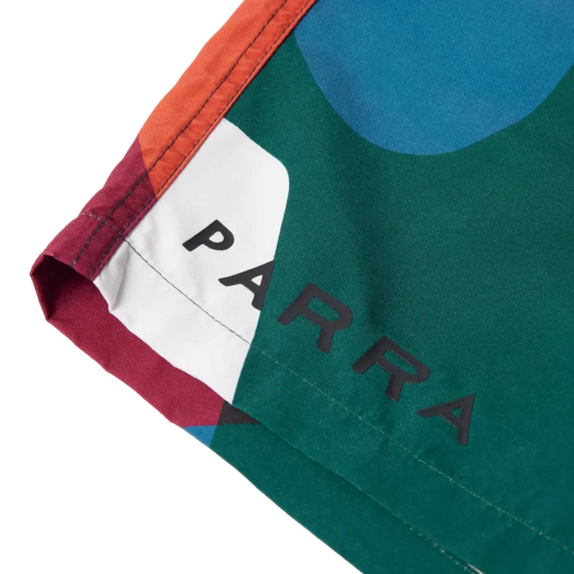 Close-up of a colorful garment with 'PARRA' branding on a white background