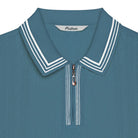 Blue polo shirt with white trim and 'Malbon' branding on a white background