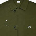 Close-up of a green textured shirt with a brand label on the collar.