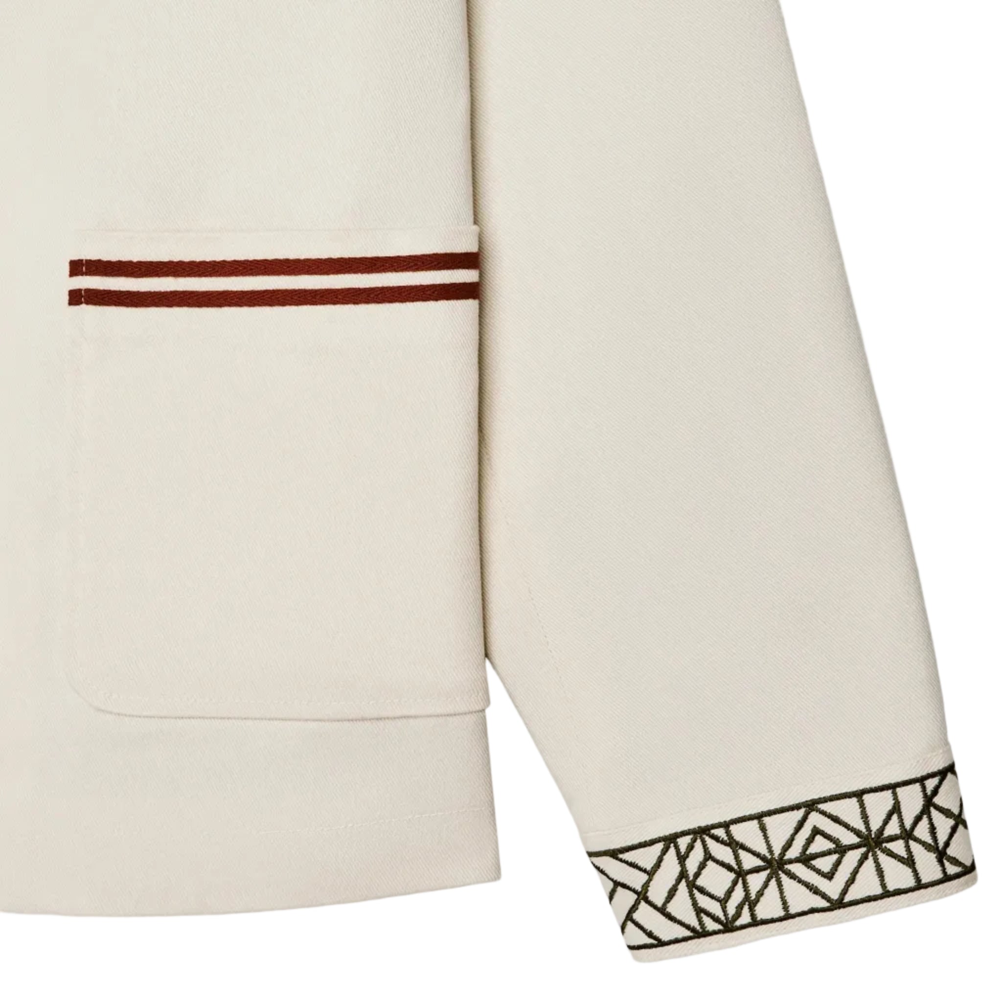 Close-up of a beige garment with geometric black pattern on a white background