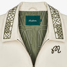 Close-up of a white jacket with geometric patterns and a brand label on a white background