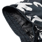 Close up of a black boardshort waistband with a mesh lining and a branded tag on a white background