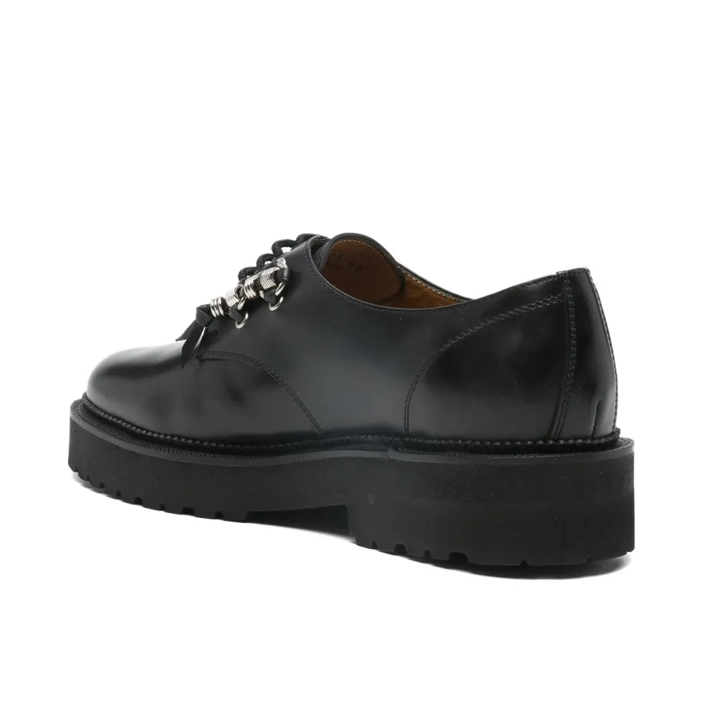 Black leather shoe with a platform sole on a white background