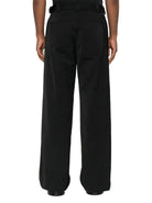 Black wide-leg pants worn by a person on a white background