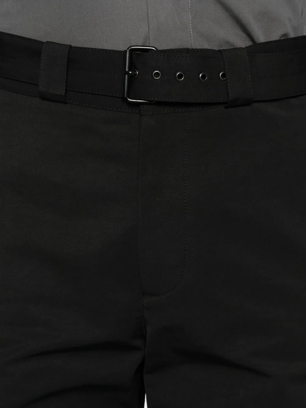 Close-up of black pants with a belt buckle.