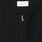 Close-up of a black garment with a zipper and 'BERNER KUHL' label.