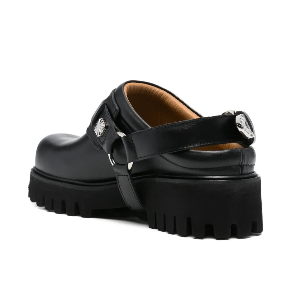 Black platform mule with a strap on a white background