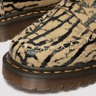 Close-up of a tan and black tiger stripe patterned shoe with brown sole.