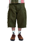 Person wearing green shorts, brown shoes, and white socks on a white background