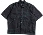 Black textured shirt with green stitching on a white background