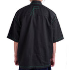 Black textured shirt with green accents on a white background