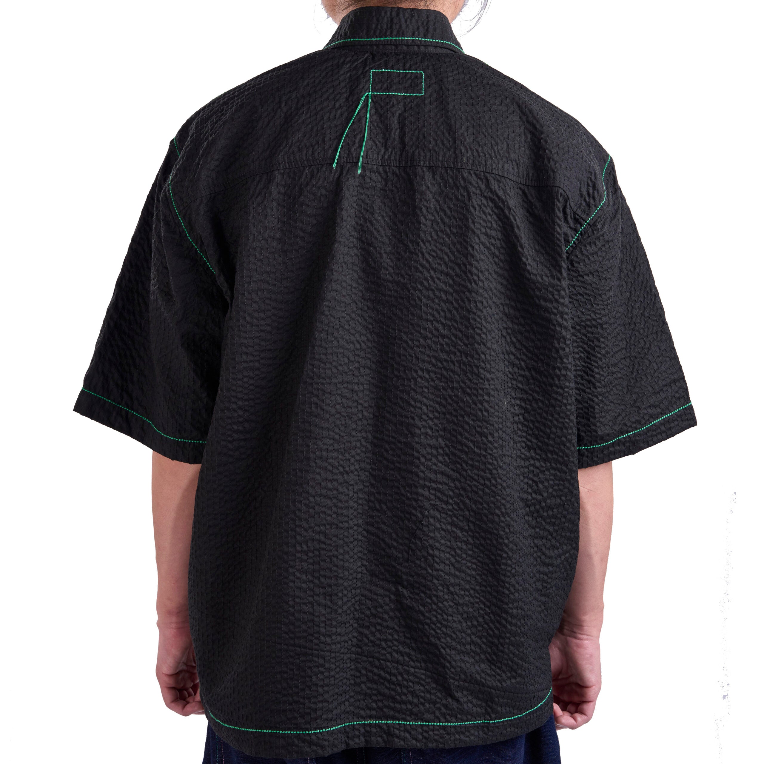 Black textured shirt with green accents on a white background