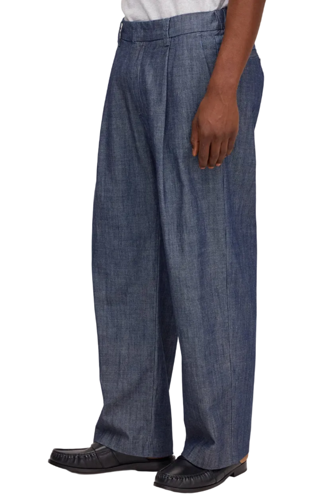 Person wearing blue pleated pants on a white background