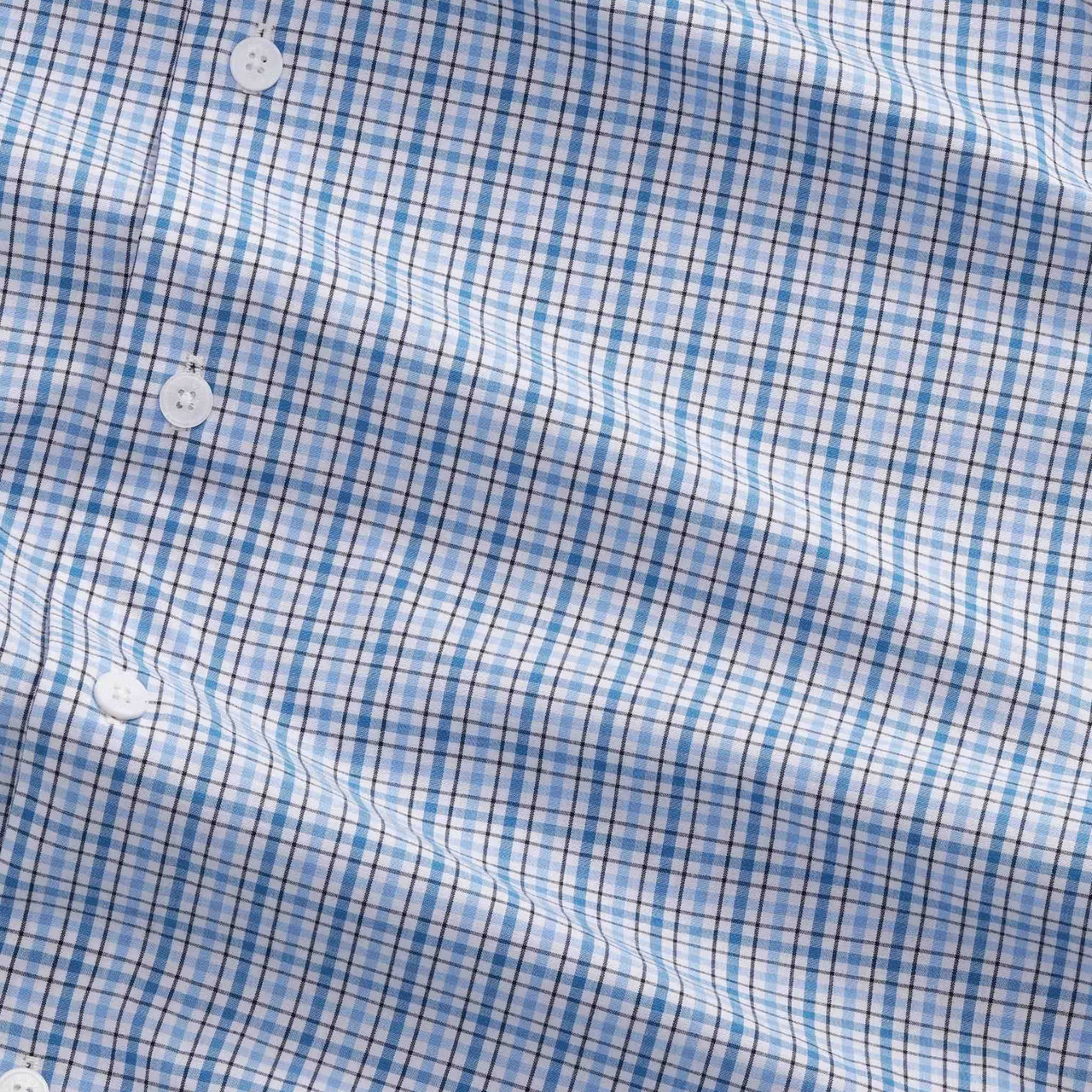 Close-up of a blue and white checkered fabric with buttons.
