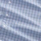 Close-up of a blue and white checkered fabric with buttons.
