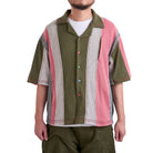 Person wearing a colorful patterned shirt with a white background