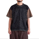Person wearing a black t-shirt with white designs on a white background