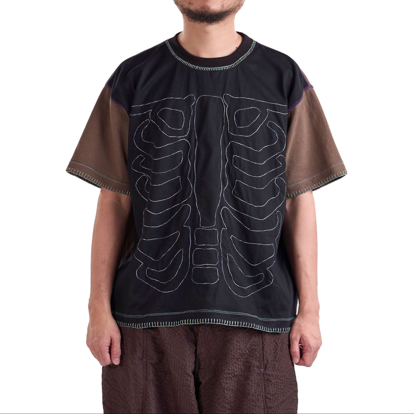 Person wearing a black t-shirt with white designs on a white background