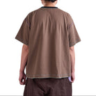 Person wearing a brown shirt and pants on a white background