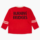 Red sweater with 'Burning Bridges' knit at the back on a white background