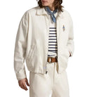 Person wearing a white jacket with an embroidered bear on the chest on a white background