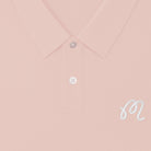 Close-up of a pink polo shirt with an 'M' logo at the chest