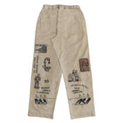 Beige pants with black embroidered vintage-style illustrations and text on both legs, featuring an elastic waistband and back pockets.