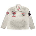 A vintage off-white canvas work jacket with multiple colorful embroidered patches on the chest and sleeves, featuring a front zipper and two zippered pockets.
