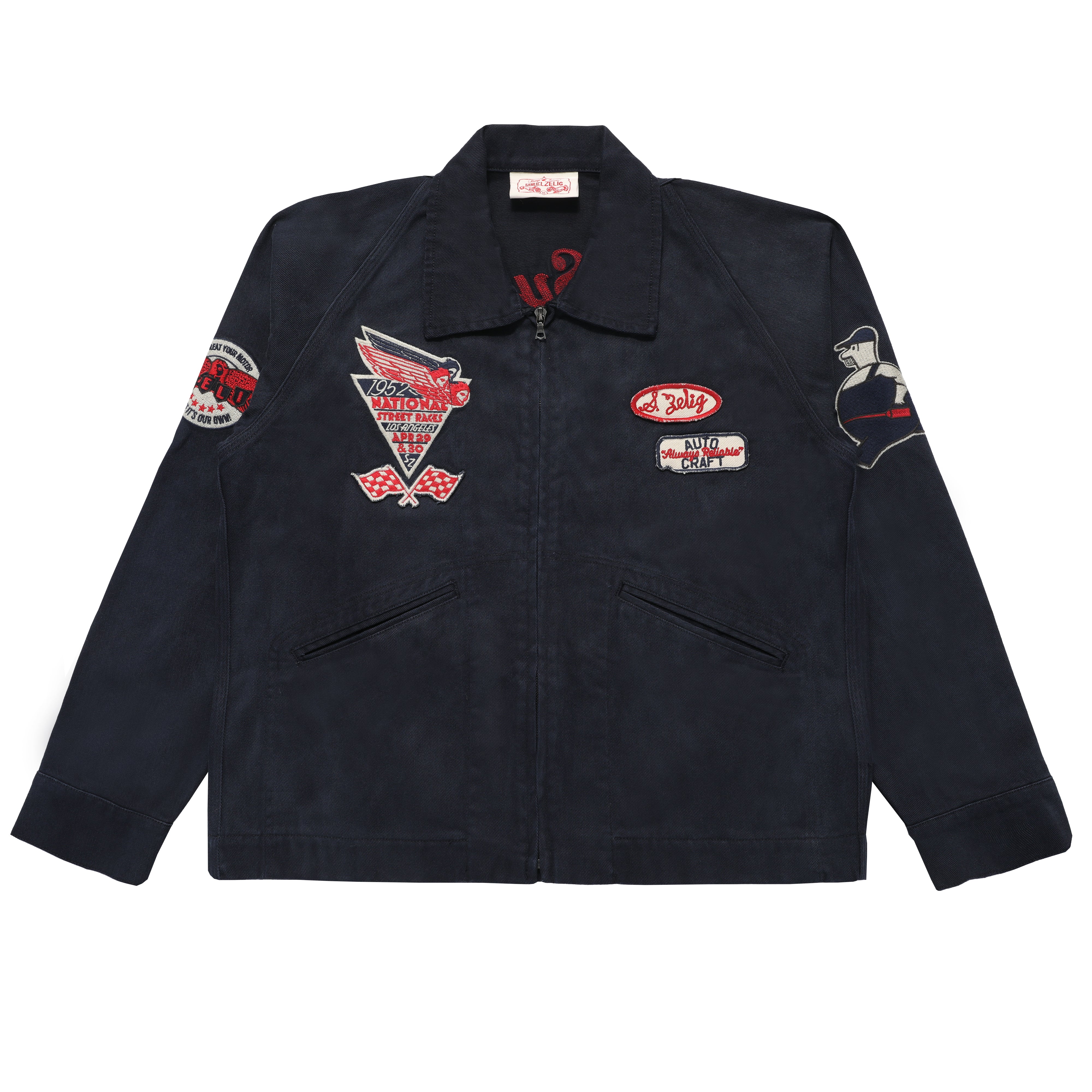 A dark navy blue zip-up work jacket with multiple embroidered patches on the chest and sleeves, displayed flat against a solid white background.