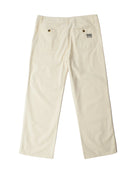 A pair of off-white canvas work pants shown from the back, featuring two back pockets with metal rivets and a small woven brand patch on the right pocket.